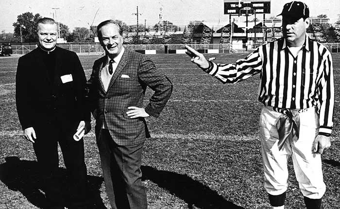 Father Roger Guindon standing with Carleton University rector Davidson Dunton during a football game in 1969